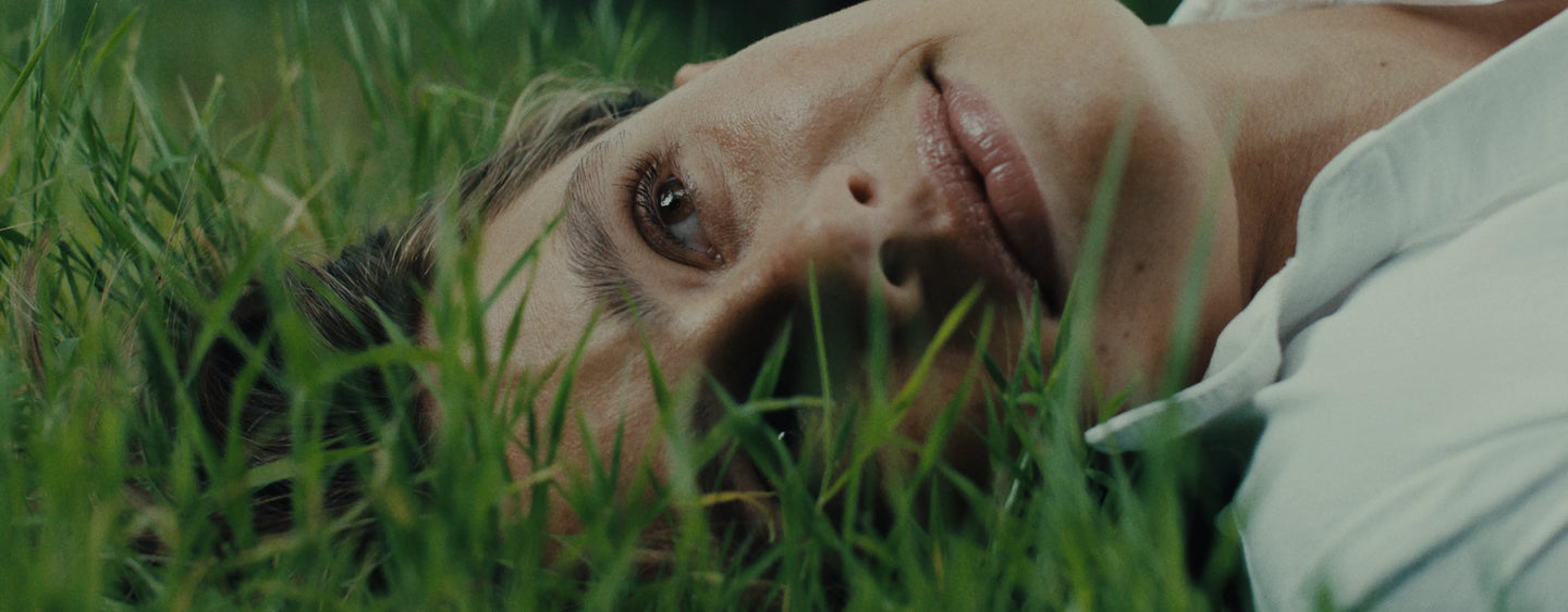 Person lying on grass with a blurred background